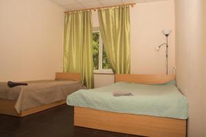 a bedroom with two beds and a window at VILLA ROZA Guest House in Rēzekne