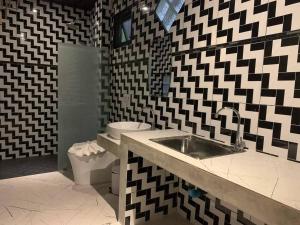 a black and white bathroom with a sink and a toilet at Grandfather Khaolak Resort in Khao Lak