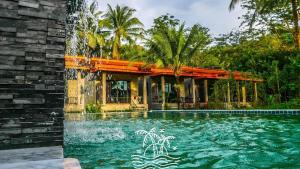 a swimming pool in front of a house at Grandfather Khaolak Resort in Khao Lak