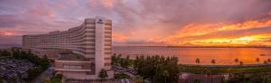 a large building with a sunset in the background at Hilton Tokyo Bay in Urayasu