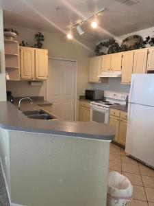 een keuken met een wastafel en een witte koelkast bij Luxury Apartment near Disney and other Theme parks in Kissimmee