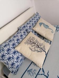 two pillows on a bed with blue and white patterns at Blue Cottage monolocale centro Sciacca in Sciacca