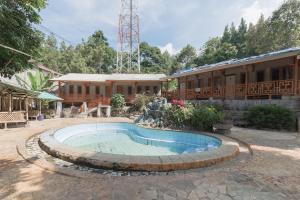 a swimming pool with a fountain in front of a building at Urbanview Hotel D'Pineapple Villa Ciater by RedDoorz in Subang