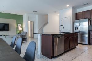 a kitchen with a sink and a refrigerator at Heated Pool Vacation Villa, Theme Room, Gated Community near Disney, Sleeps 12! in Kissimmee