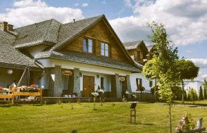 una casa grande con un patio de hierba delante de ella en Hotel Gość w dom 
