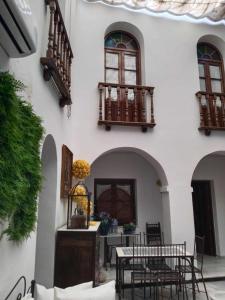 eine Terrasse mit Tischen und Stühlen in einem Gebäude in der Unterkunft Hostel Mayflowers in Córdoba