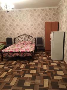 a bedroom with a bed and a refrigerator at Guest house Kabardinskaya 121 in Gagra