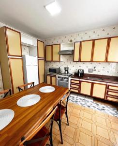 a kitchen with a wooden table with chairs and a stove at Ap401 Praia do morro in Guarapari