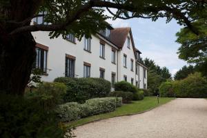 un bâtiment blanc avec des fenêtres noires et une allée. dans l'établissement DoubleTree by Hilton Oxford Belfry, à Thame