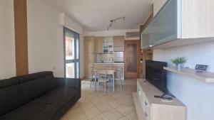 uma sala de estar com um sofá preto e uma cozinha em WH - Bussana em Sanremo