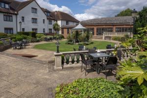 a courtyard with tables and chairs and a building at DoubleTree by Hilton Oxford Belfry in Thame