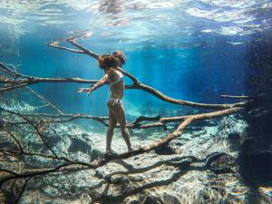 Machame的住宿－Machame Homestay and Cultural Tourism，站在水中树枝上的女人