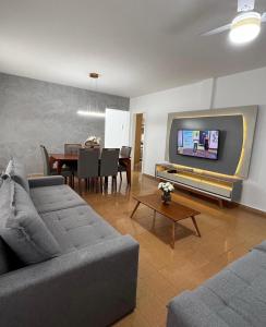 a living room with a couch and a dining room at Ap401 Praia do morro in Guarapari