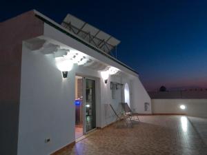 a white building with lights on it at night at Cozy Studio with Rooftop Terrace & Cityscape Views in Le Bardo