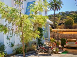 a motorcycle parked in front of a house at Hotel Blue Valley in Mount Ābu