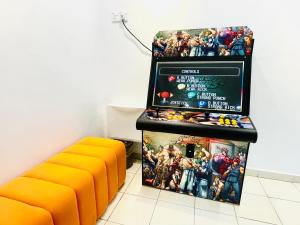 einen orangenen Stuhl neben einer Ausstellung von wunderbaren Comics in der Unterkunft EE Summer Guest House 3.0 in Seremban