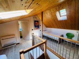 德爾維奧的住宿－Bellavista Giulia on Lake Como，一间设有木制天花板和楼梯的客房