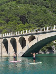 2 personnes sur des planches de surf dans l'eau sous un pont dans l'établissement Moli l'Abad, à Puebla de Benifasar