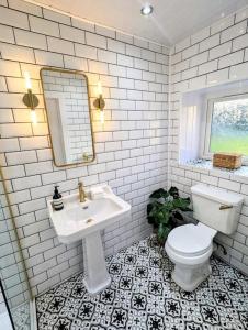 a white bathroom with a sink and a toilet at The Cottage @ 59 in Colmonell