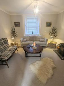 sala de estar con sofá y mesa en The Cottage @ 59, en Colmonell