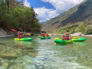 a group of people in kayaks on a river at Azimut Hiša in Tolmin