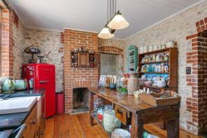 a kitchen with a red refrigerator and a brick wall at Benny's Beach House in Encounter Bay