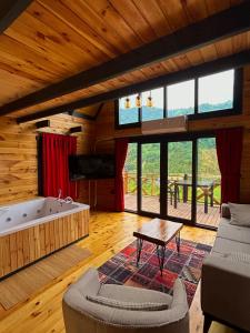 a living room with a tub and a table at CİLEMONA SUİT BUNGALOWS in Ardeşen