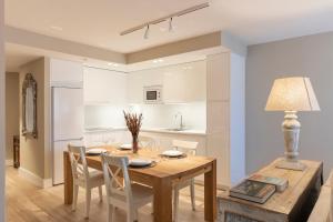 eine Küche und ein Esszimmer mit einem Holztisch und Stühlen in der Unterkunft Apartamentos Plaza Center in Suances