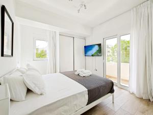 a white bedroom with a large bed and windows at Marathonomachon Apartments by Verde Apartments in Athens