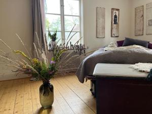Un dormitorio con una cama y un jarrón con flores. en Boutique Hotel Caramel en Jönköping