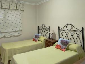 2 Betten in einem Zimmer mit gelber Bettwäsche in der Unterkunft Live Costa Adeje Terraza y piscina in Adeje