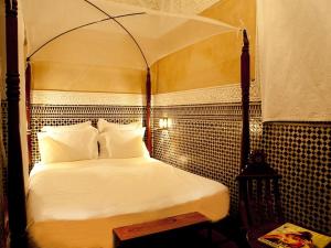 - une chambre avec un lit blanc à baldaquin dans l'établissement Riad ka, à Marrakech