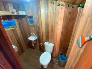 uma casa de banho em madeira com um WC e um lavatório em Pousada AldeiA Cotijuba em Belém