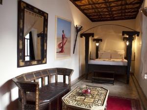 Habitación con cama, mesa y espejo. en riad ka-Frida productions, en Marrakech