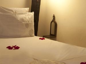 - un lit avec des pétales de rose rouge dans l'établissement Riad ka, à Marrakech