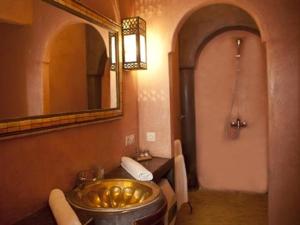 baño con lavabo de oro y espejo en riad ka-Frida productions, en Marrakech