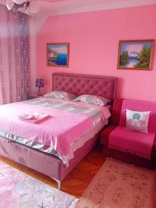 - une chambre rose avec un lit et une chaise dans l'établissement Guest House Cinderella, à Herceg-Novi