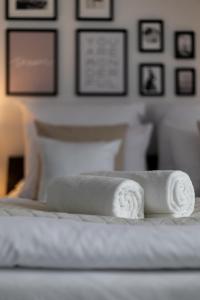 two rolled towels sitting on top of a bed at Aparthotel Solskiego Wrocław in Wrocław