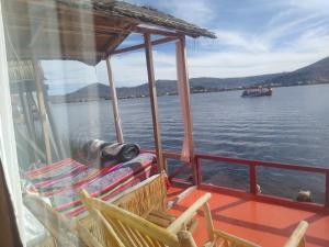 a boat on the water with a view of the water at Uros Titicaca Mallku lodge in Puno