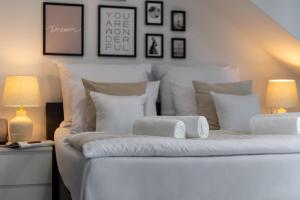 - une chambre dotée d'un lit blanc avec des oreillers et 2 lampes dans l'établissement Aparthotel Solskiego Wrocław, à Wrocław