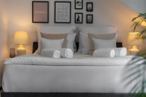 a bedroom with a white bed with towels on it at Aparthotel Solskiego Wrocław in Wrocław