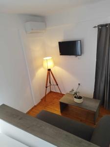 阿奇翁的住宿－PETMEZA TOP BY DIMITROPOULOS，客厅配有桌子和墙上的电视