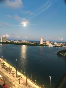 uma vista para um rio com uma cidade ao fundo em Aconchegante, ótima localização e vista para o mar no Recife