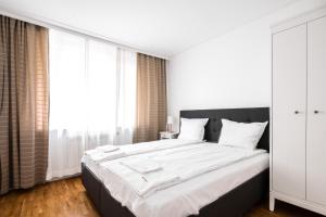 een slaapkamer met een groot bed met witte lakens bij Contemporary Comfort: 1BD Flat in Lozenetz, Sofia in Sofia