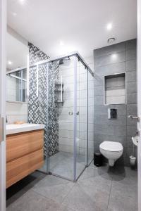 een badkamer met een glazen douche en een toilet bij Contemporary Comfort: 1BD Flat in Lozenetz, Sofia in Sofia