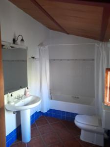 y baño con lavabo, bañera y aseo. en Casa El Castillo, en Teba