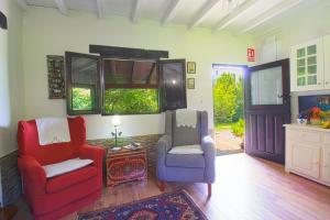 ein Wohnzimmer mit 2 Stühlen und einem TV in der Unterkunft Cabaña El Planto in Torrelavega