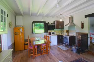 eine Küche mit einem Holztisch und eine Küche mit einem Tisch in der Unterkunft Cabaña El Planto in Torrelavega