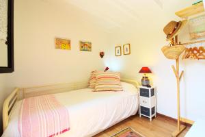 Dormitorio pequeño con cama y lámpara en Cabaña El Planto, en Torrelavega