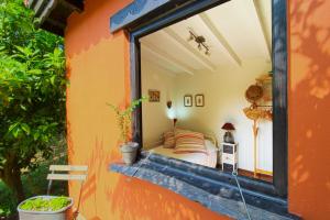 Un pequeño dormitorio con una cama en una ventana en Cabaña El Planto, en Torrelavega